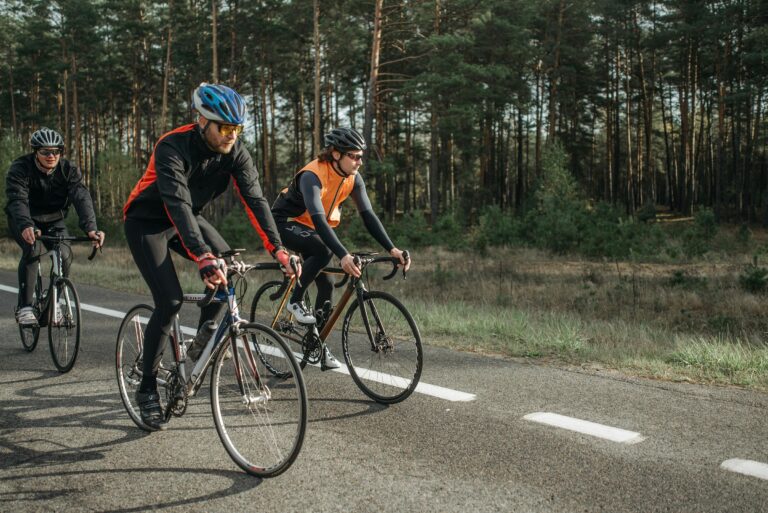 Three men cycling down a road.