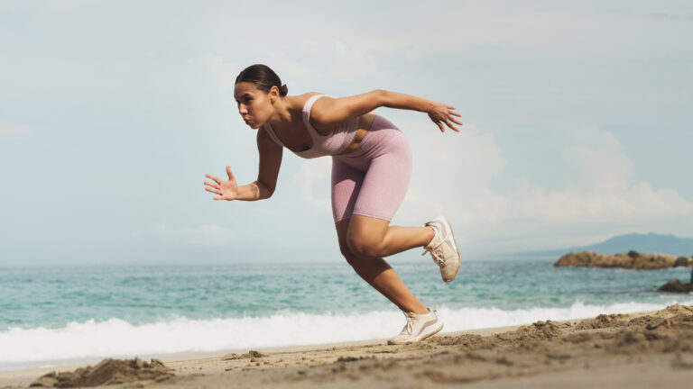 Woman doing running drills on a beach for importance of adaptations