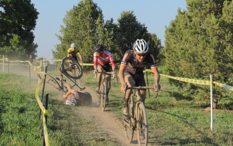 One athlete crashing into the dirt in a line of cyclocross riders