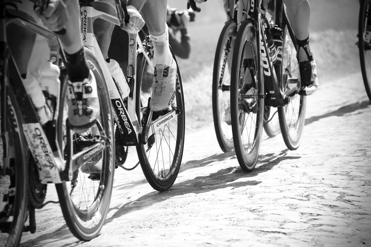 Black and white photo of cyclists on gravel