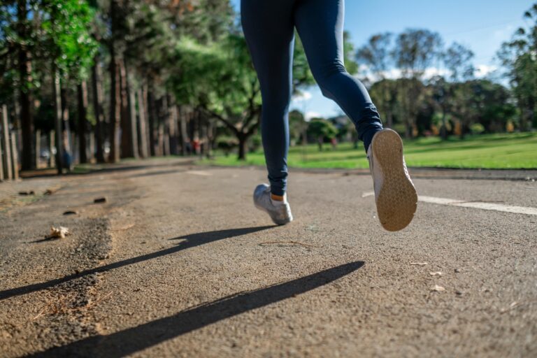 Runner on sidewalk trail in park