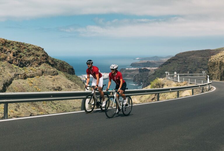 Two cyclists near railing of elevated road during endurance training