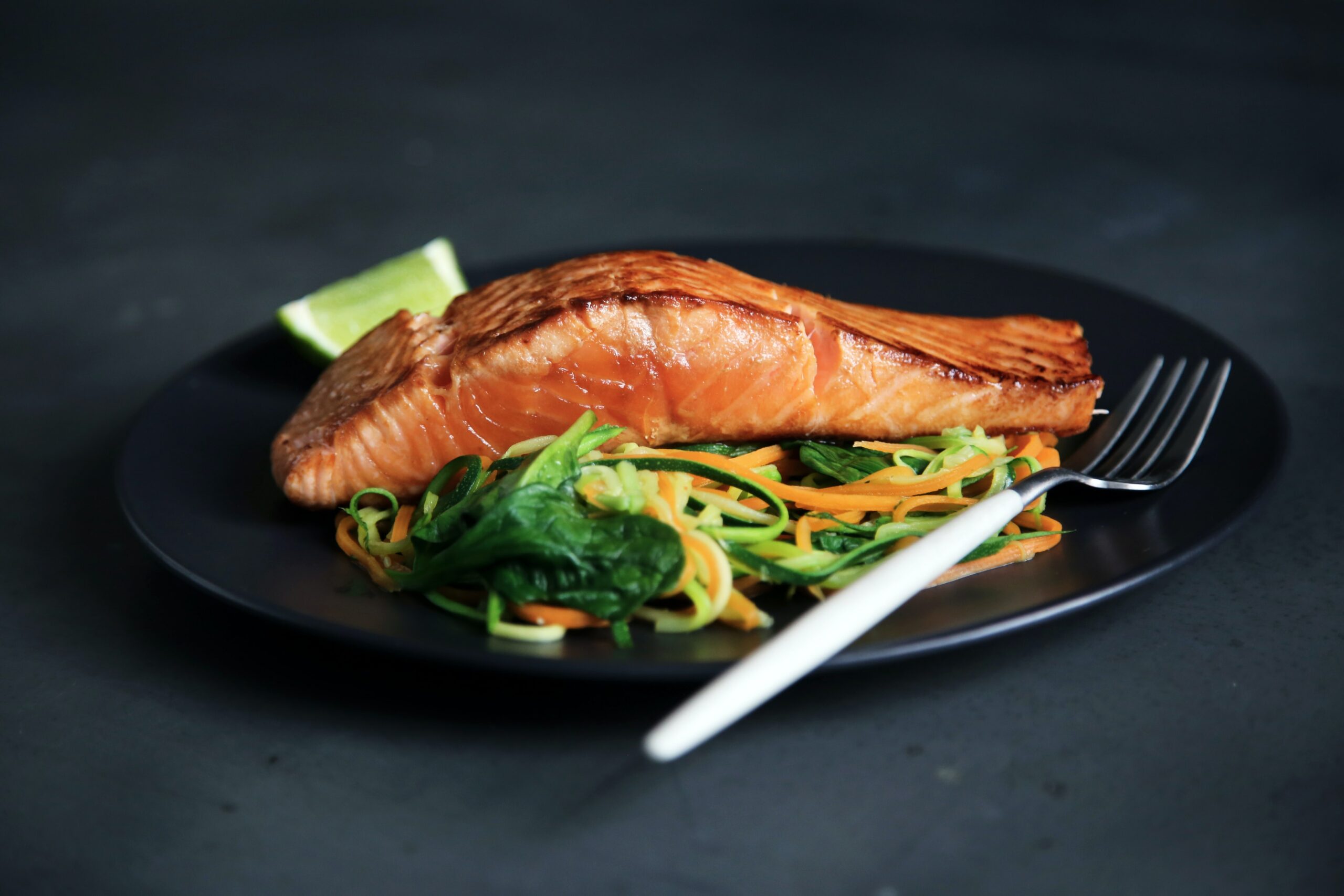 Filet of Salmon on Plate with Salad, Lime and Fork