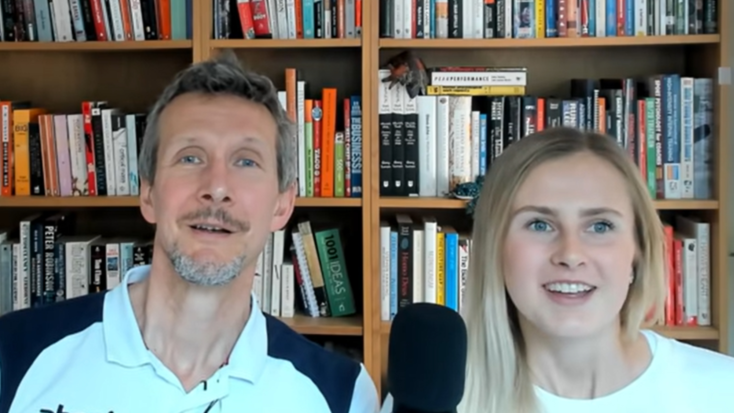 Stephen Seiler and his daughter Siren sit in front of a bookshelf