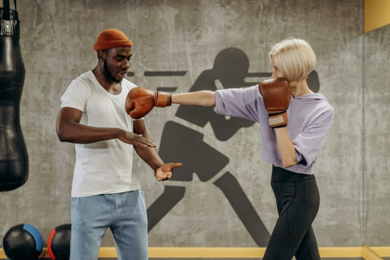 male coach instructing a female kickboxer