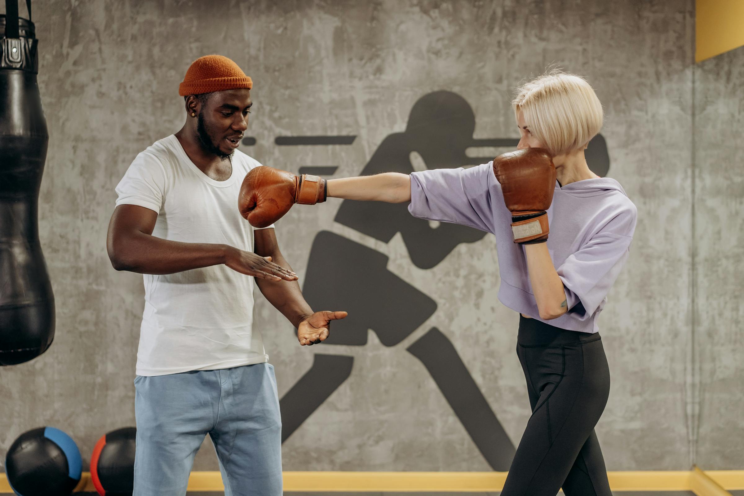 male coach instructing a female kickboxer