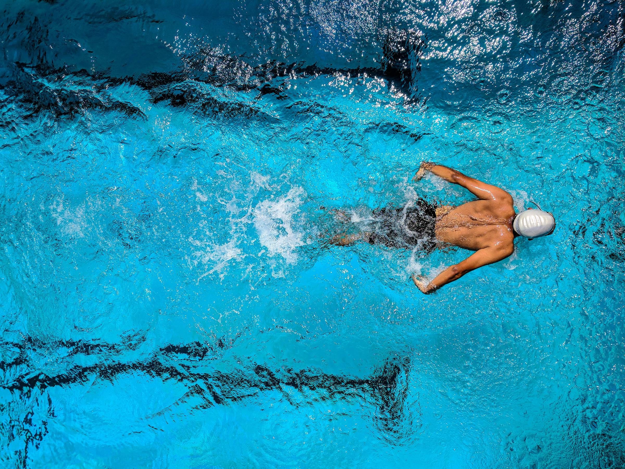 man swimming in a pool aerial view