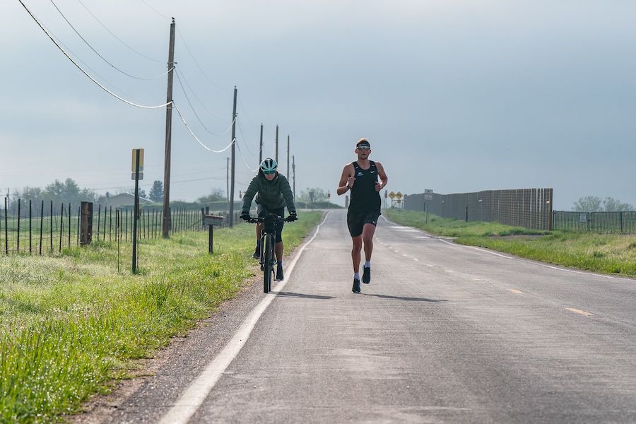 Julie Dibens riding alongside one of her athletes, pro triathlete Justin Metzler.