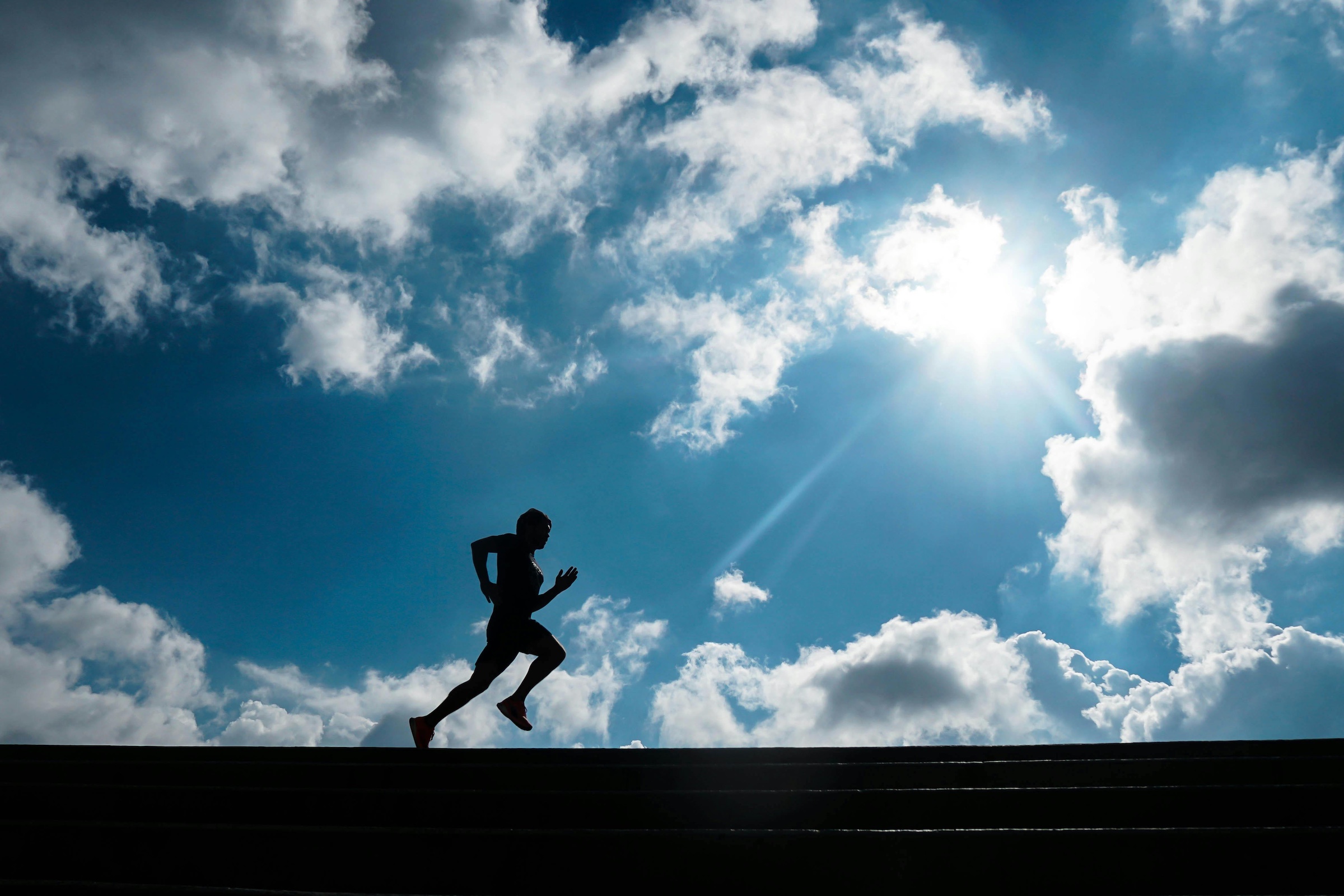 silhouette of runner in sunlight for polarized training running workouts