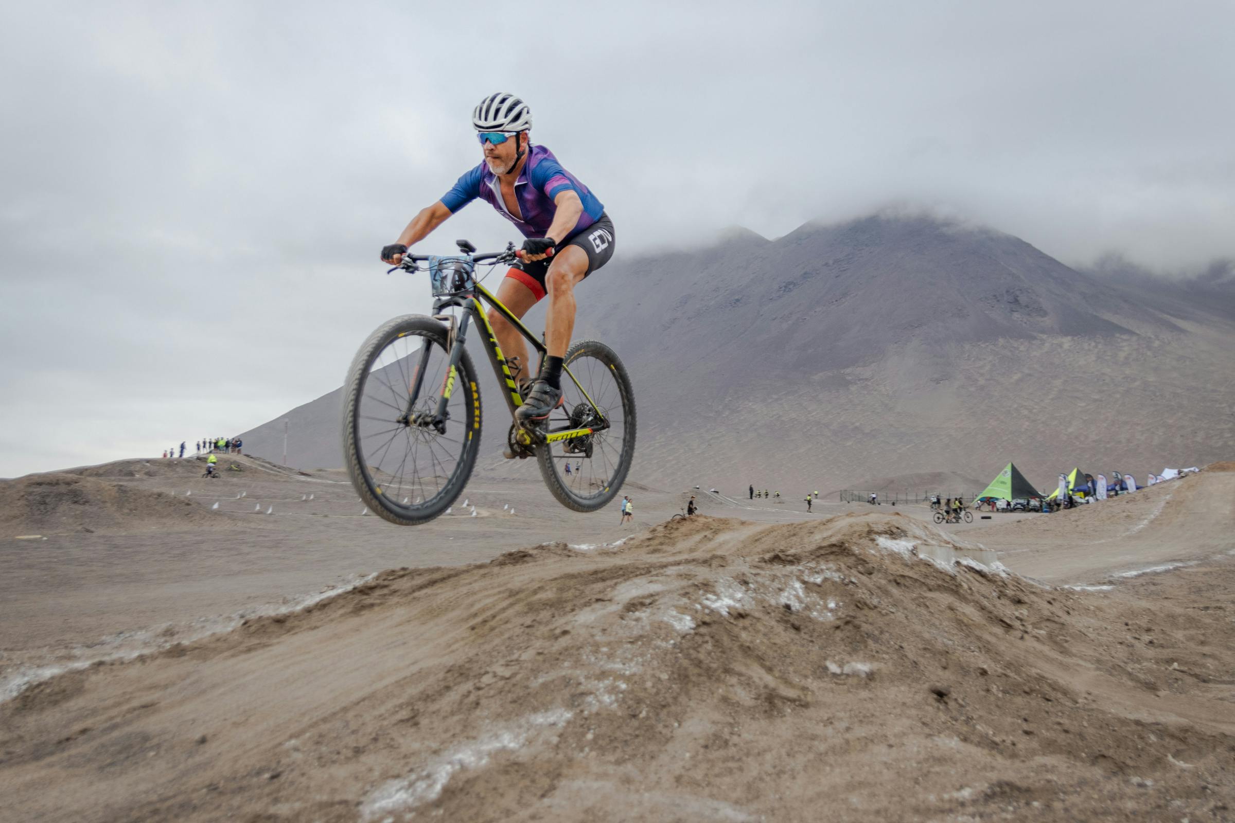 male cyclist in midair on rough terrain