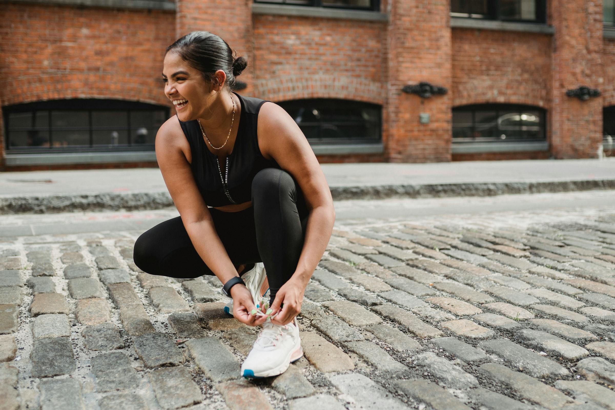 joyful athlete lacing up her shoes