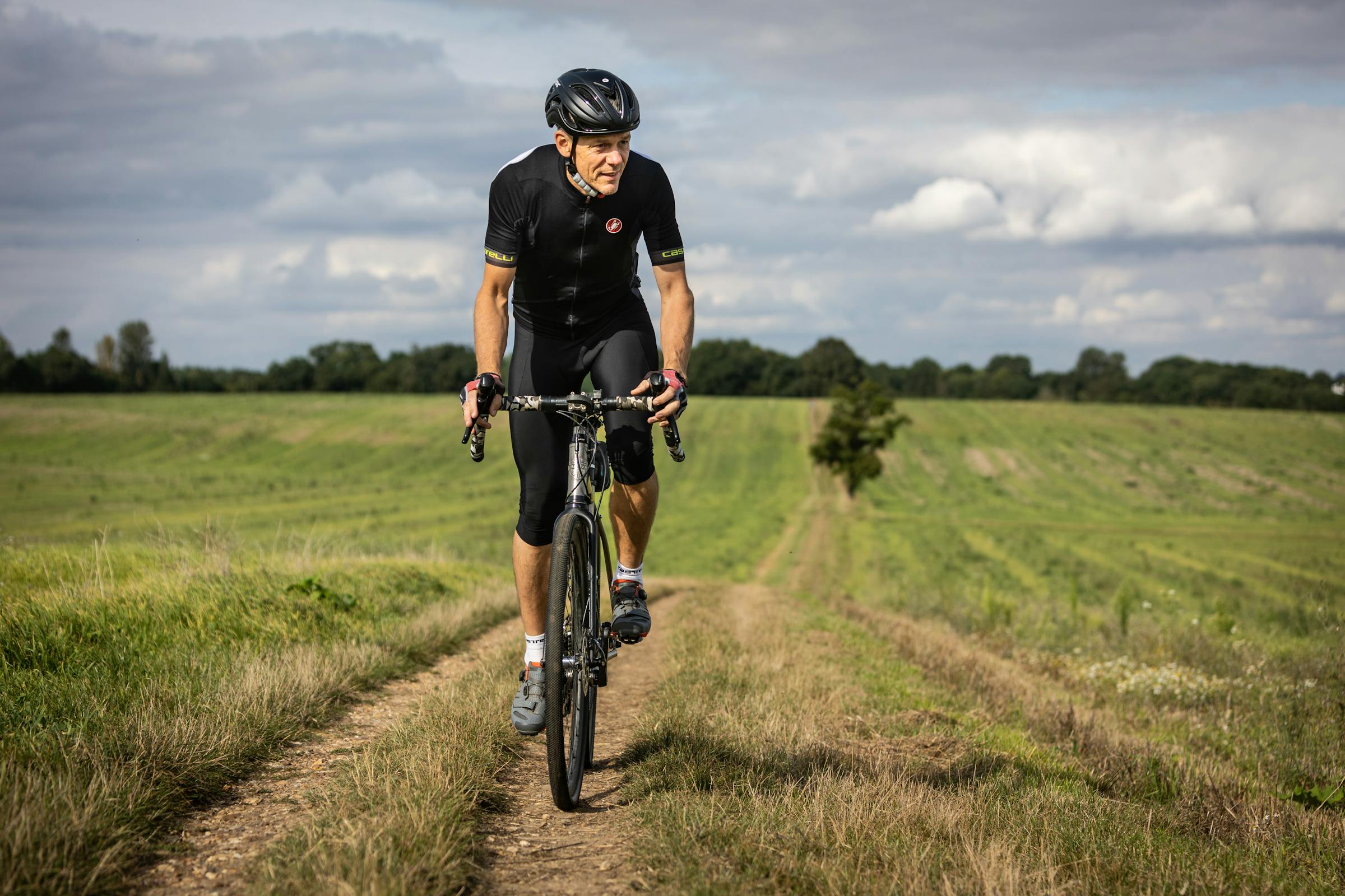 man doing a cycling workout on a rural road