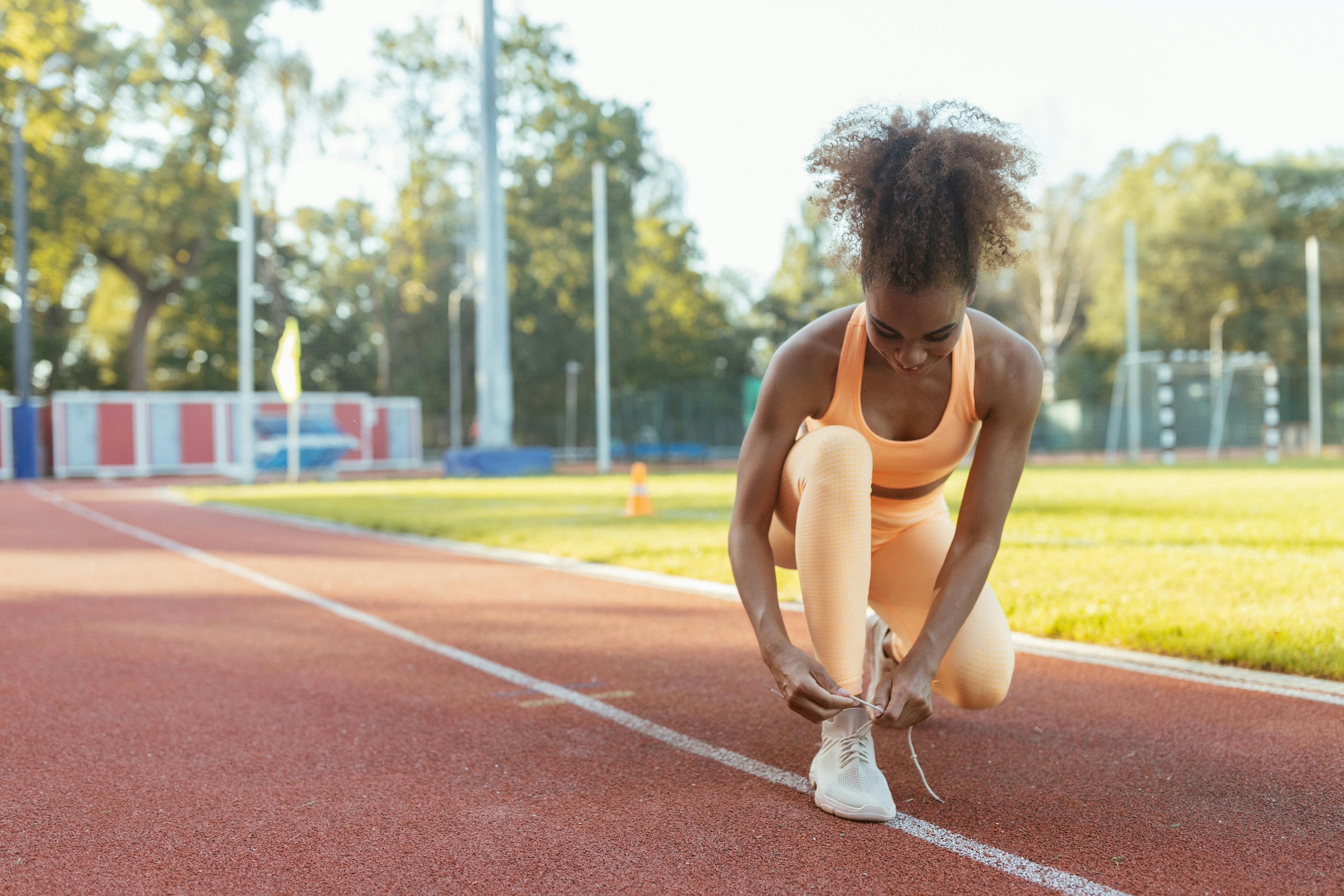 Women tying her shoe on the track.
