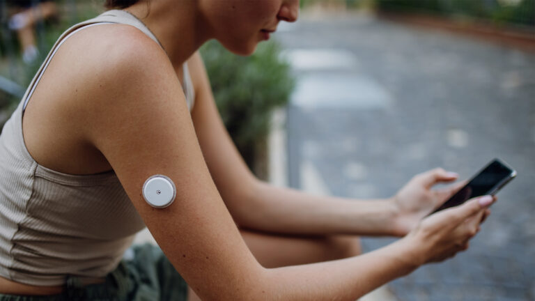 Woman wearing a continuous lactate monitor on her arm.