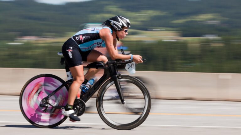 Blurred image of a woman riding a bike with aerobars.