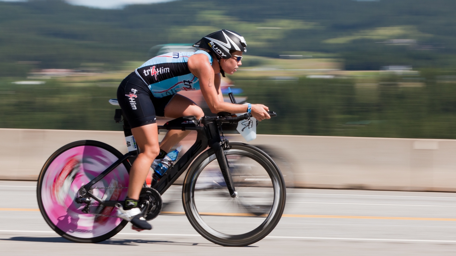 Blurred image of a woman riding a bike with aerobars.