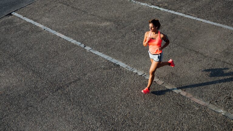Woman running across asphalt