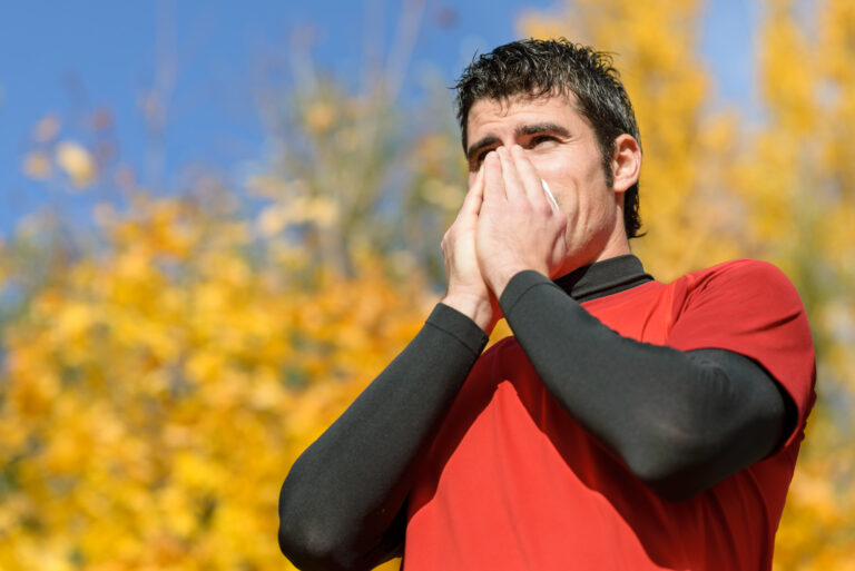Flu And Cold sick Man. Young Athlete Coughing And Blowing On