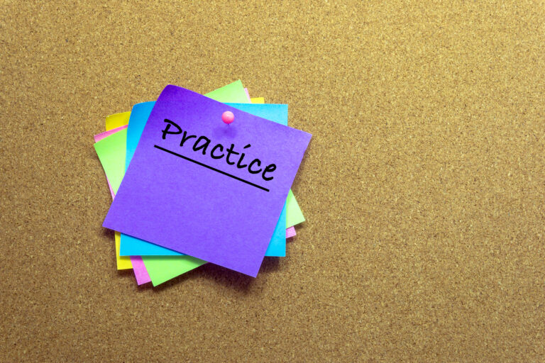 the word 'practice' on a post-it note on a wall. Practicing leads to performance gains.